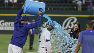 El venezolano Martín Pérez vacía la hielera sobre el dominicano Ezequiel Durán, su compañero de los Rangers de Texas, quienes vencieron el martes 2 de mayo de 2023 a los Diamondbacks de Arizona (AP Foto/Michael Ainsworth)