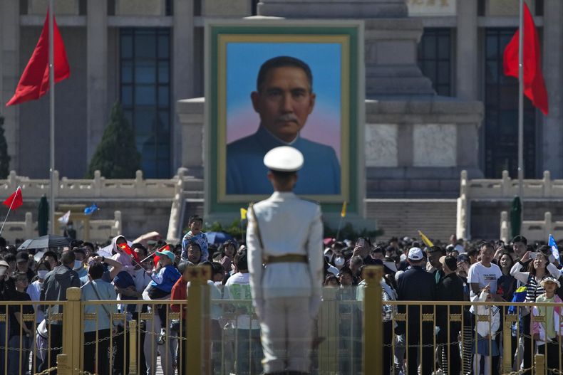 Visitantes reunidos junto a un retrato de Sun Yat-sen, ampliamente considerado como el fundador de la China moderna, en la Plaza Tiananmen durante los festejos del Día de Trabajo en Beijing, el domingo 30 de abril de 2023. (AP Foto/Andy Wong)
