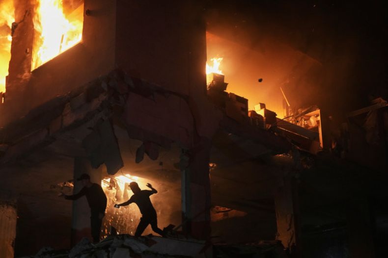 Palestinos huyen de un incendio tras un ataque israelí en un edificio residencial en el vecindario de Rimal, el viernes 15 de mayo de 2026, en Ciudad de Gaza. (AP Foto/Jehad Alshrafi)