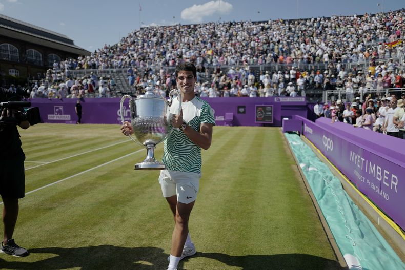 Carlos Alcaraz carga el trofeo de campeón del torneo del Queens Club tras derrotar a Alex de Miñaur en la final, el domingo 25de junio de 2023, en Londres. (AP Foto/Alberto Pezzali)