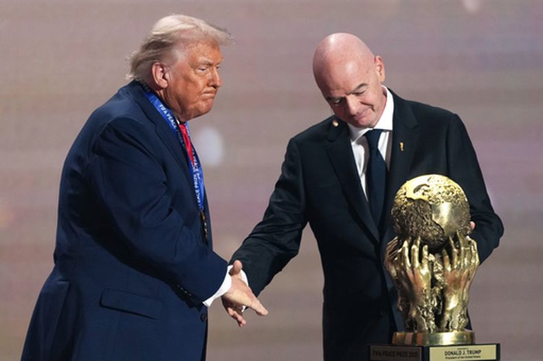 ARCHIVO - El líder de la FIFA Gianni Infantino entrega al presidente estadounidense Donald Trump un premio por la paz durante el sorteo del Mundial, el viernes 5 de diciembre de 2025 en Washington (AP Foto/Stephanie Scarbrough, Pool, archivo)