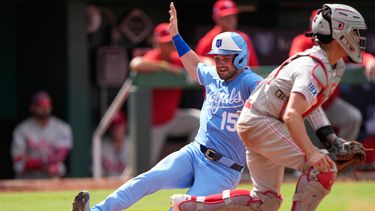 Lane Thomas (15), de los Reales de Kansas City, llega barrido al plato mientras el receptor Garrett Stubbs, de los Filis de Filadelfia, para anotar con un doble productor de dos carreras de Salvador Pérez durante la octava entrada del juego de béisbol de las Grandes Ligas, el domingo 5 de julio de 2026, en Kansas City, Missouri. (AP Foto/Charlie Riedel)