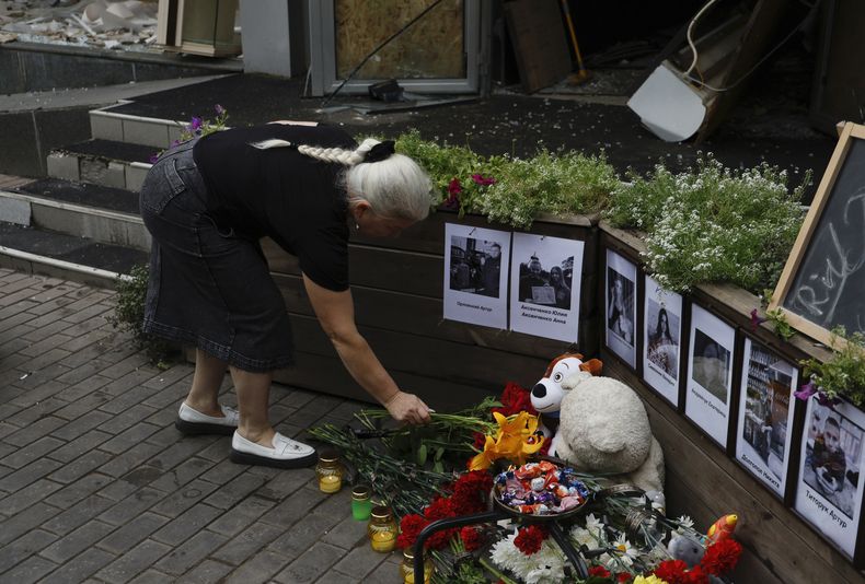 Una mujer local coloca flores en el altar improvisado ante la pizzería RIA, atacada por un cohete ruso en Kramatorsk, en la región de Donetsk, Ucrania, el jueves 29 de junio de 2023. (AP Foto/Alex Babenko)