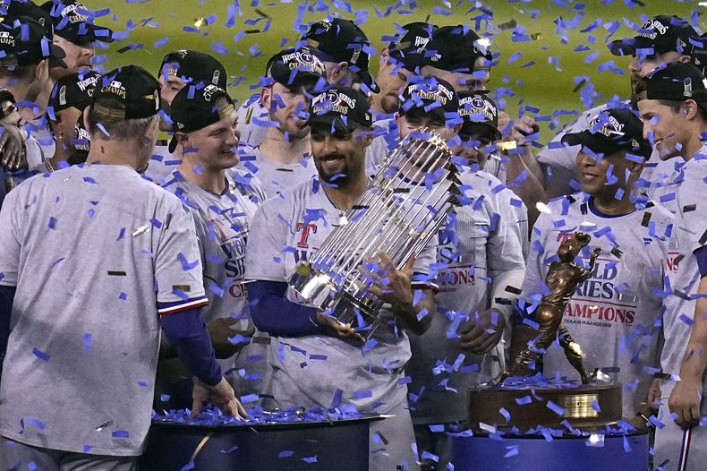 Marcus Semien, de los Rangers de Texas, levanta el trofeo de la Serie Mundial, tras el triunfo sobre los Diamondbacks de Arizona, el miércoles 1 de noviembre de 2023 (AP Foto/Gregory Bull)