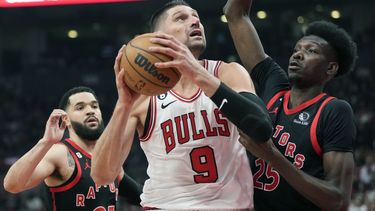 ARCHIVO - Nikola Vucevic (9), pívot de los Bulls de Chicago, busca encestar con la presión defensiva de Chris Boucher (25), de los Raptors de Toronto y Fred VanVleet (23), durante la primera mitad del juego de baloncesto de la NBA, en el torneo play-in, el miércoles 12 de abril de 2023, en Toronto. Los Bulls y Nikola Vucevic acordaron el miércoles 28 de junio de 2023 a una extensión de contrato de tres años y 60 millones de dólares. (Frank Gunn/The Canadian Press via AP, Archivo)