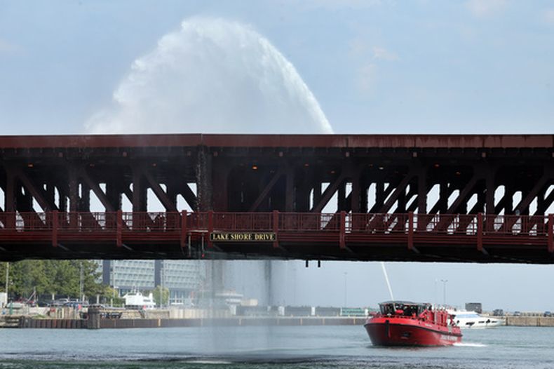 Agua bombeada por una embarcación del Departamento de Bomberos de Chicago cae sobre el puente DuSable Lake Shore Drive que cruza el río Chicago, el miércoles 2 de septiembre de 2026. El puente —de doble hoja, dos niveles y contrapeso fijo— se había quedado atascado anteriormente ese mismo día. (Terrence Antonio James/Chicago Tribune vía AP)