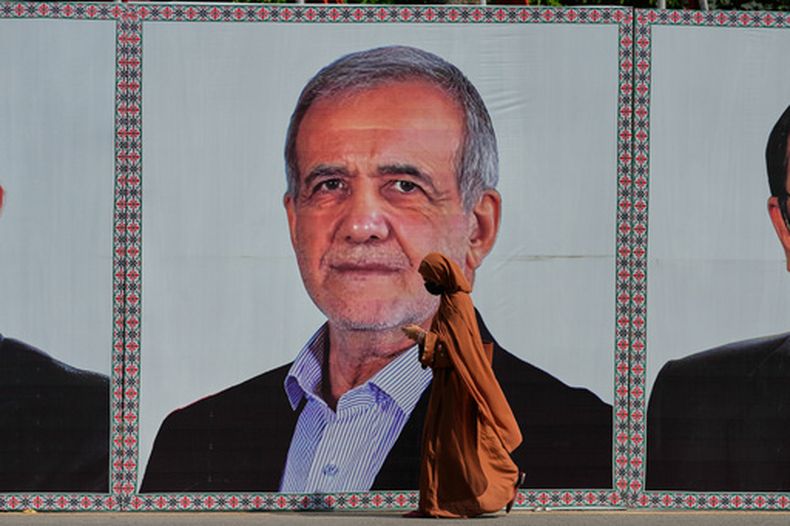 Una mujer pasa frente a un anuncio con la imagen del presidente de Irán, Masoud Pezeshkian, el martes 23 de junio de 2026, en Islamabad, Pakistán. (AP Foto/Anjum Naveed)