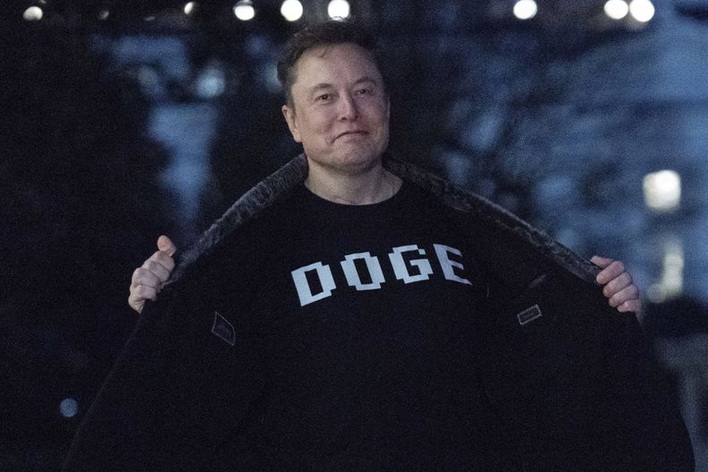 ARCHIVO - Elon Musk muestra su camiseta que dice DOGE a los medios mientras camina por el jardín sur de la Casa Blanca, en Washington, el 9 de marzo de 2025. (AP Foto/José Luis Magaña, Archivo)