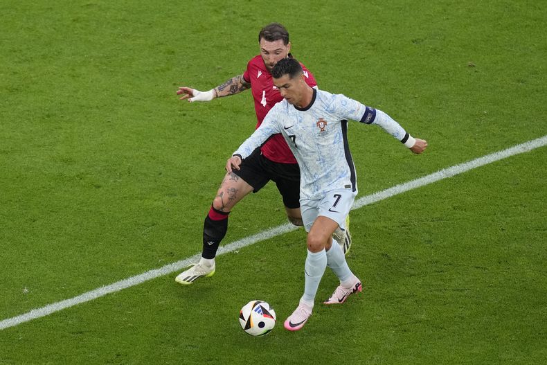 El portugués Cristiano Ronaldo pelea por el balón ante Guram Kashia de Georgia en e encuentro del Grupo F de la Eurocopa el miércoles 26 de junio del 2024. (AP Foto/Andreea Alexandru)