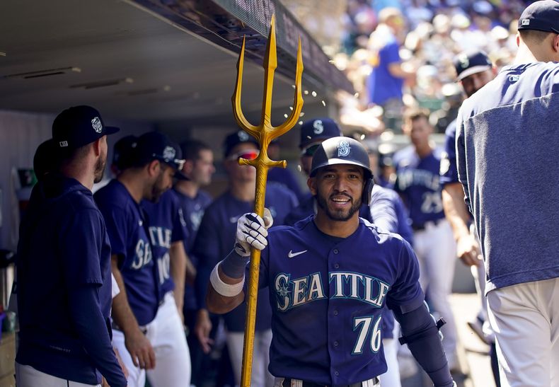José Caballero, de los Marineros de Seattle, sostiene un tridente en la banca después de batear un cuadrangular en contra de los Nacionales de Washington durante la octava entrada del juego de béisbol, el miércoles 28 de junio de 2023, en Seattle. (AP Foto/Lindsey Wasson)