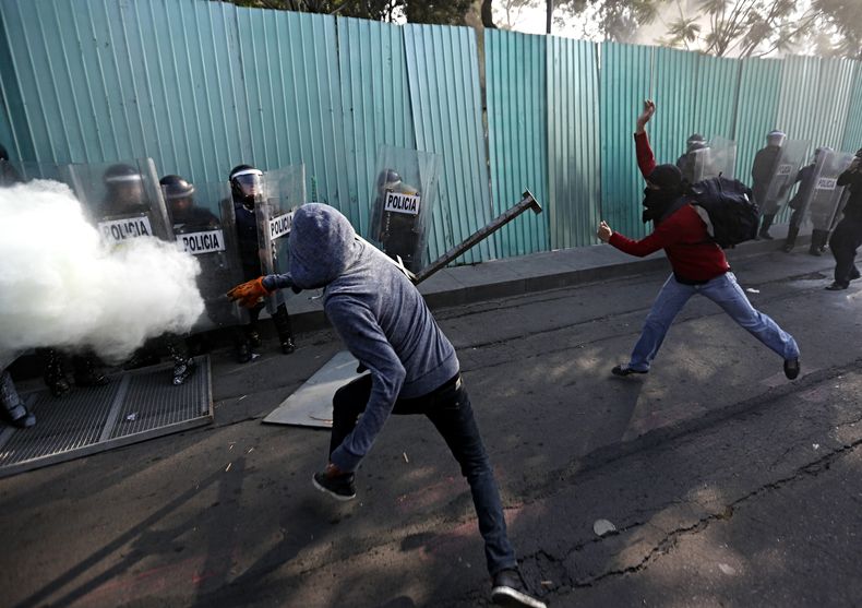 Manifestantes enmascarados se enfrentan contra polic&iacute;as antimotines durante una marcha que conmemora el aniversario de la masacre de Tlatelolco el mi&eacute;rcoles 2 de octubre de 2013 en la Ciudad de M&eacute;xico. (Foto AP/Eduardo Verdugo)