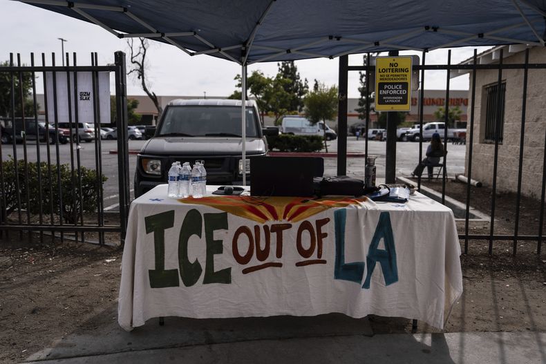 Una mesa cubierta con un mantel en el que se lee ICE fuera de Los Ángeles se encuentra bajo un toldo junto al centro de empleo para jornaleros, afuera de una tienda Home Depot en el barrio de Van Nuys, en Los Ángeles, el 28 de agosto de 2025. (AP Foto/Jae C. Hong)