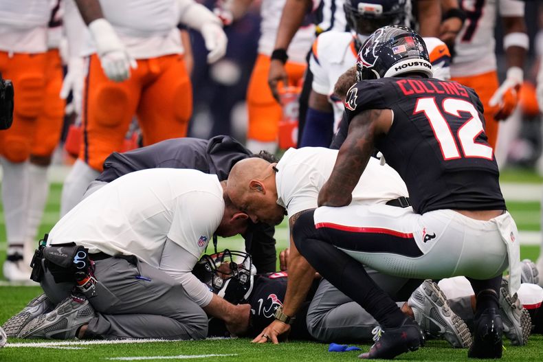Nico Collins arrodillado observa al cuerpo técnico auxiliando al quarterback de los Texans de Houston C.J. Stroud, quien está tendido en el suelo tras recibir un golpe en el encuentro ante los Broncos del domingo 2 de noviembre del 2025. (AP Foto/Eric Christian Smith)