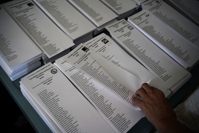 Un votante elige una boleta del Partido Socialista en un centro de votación en las elecciones generales, el 23 de julio de 2023, en Madrid. (AP Foto/Andrea Comas)