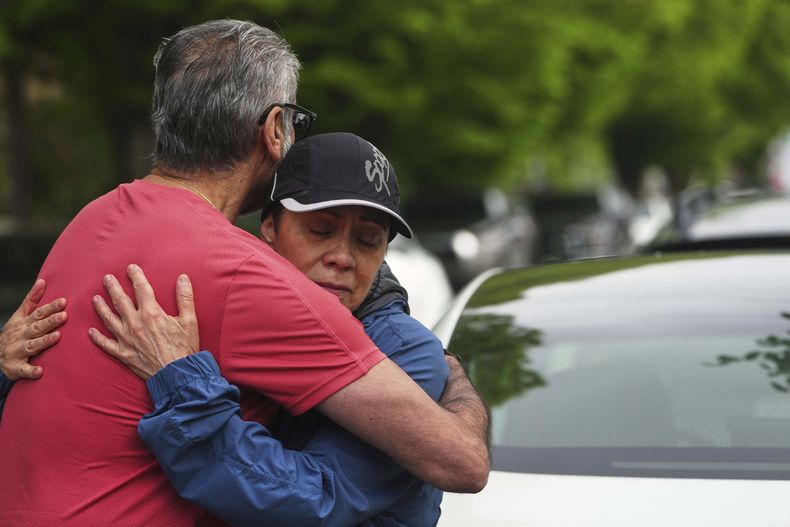 Esperanza Bermudez, quien vive frente a la calle, recibe consuelo de sus amigo Manjit Claire, de rojo, momentos después de que un conductor mató a varias personas al embestir con su auto un festival de la comunidad filipina, el domingo 27 de abril de 2025, en Vancouver, Canadá. (AP Foto/Lindsey Wasson)