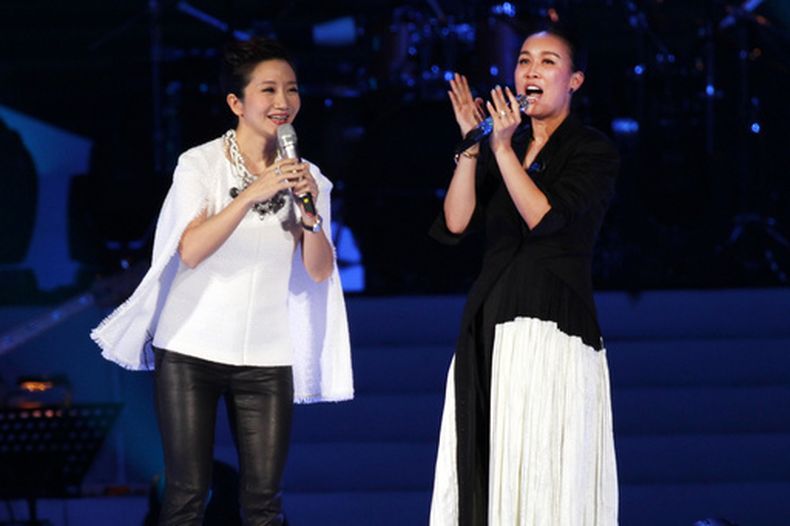 ARCHIVO - La cantante china Na Ying, derecha, y la cantante taiwanesa Matilda Tao actúan durante un concierto benéfico para niñas víctimas de abusos en el Taipei Arena de Taipéi, Taiwán, el 20 de abril de 2014. (Foto AP /Chiang Ying-ying, archivo)