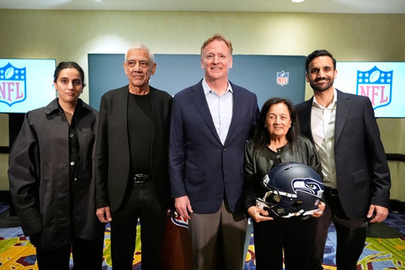 La familia de Vinod Khosla (segundo desde la izquierda), nuevo dueño de los Seahawks de Seattle, posa con el comisionado de la NFL Roger Goodell (centro) durante una rueda de prensa, el miércoles 26 de agosto de 2026, en Atlanta. (AP Foto/Brynn Anderson)