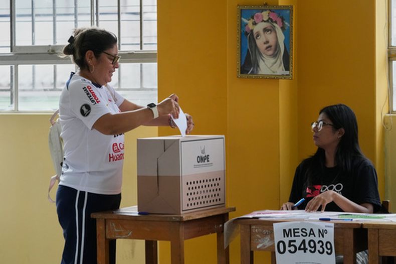 Una mujer vota mientras se reanuda la votación en un colegio electoral afectado por retrasos y problemas logísticos durante las elecciones generales en Lima, Perú, el lunes 13 de abril de 2026. (AP Foto/Martín Mejía)