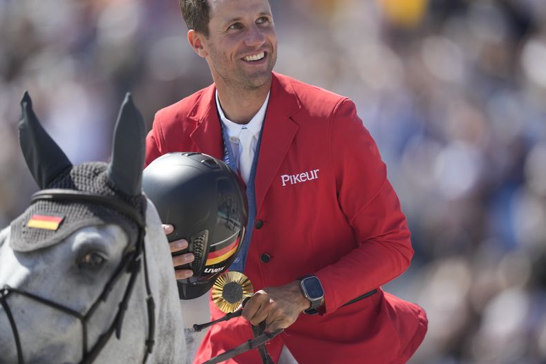 El alemán Christian Kukuk, en los lomos de Checker 47, celebra tras ganar la medalla de oro en la final de saltos individuales de la equitación de los Juegos Olímpicos de París, el martes 6 de agosto de 2024 en Versalles, Francia. (AP Foto/Mosaab Elshamy)