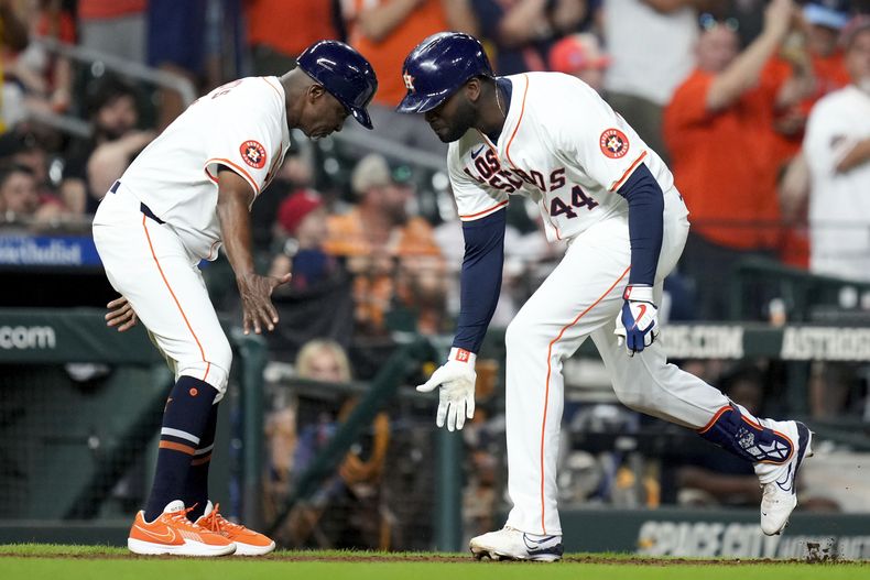El cubano Yordan Álvarez, de los Astros de Houston, festeja con el coach de la antesala Gary Pettis luego de batear un jonrón ante los Angelinos de Los Ángeles, el sábado 21 de septiembre de 2024 (AP Foto/Eric Christian Smith)