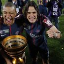 ARCHIVO - Edinson Cavani (derecha) y Kylian Mbappé con el trofeo de campeones de la la Copa de la Liga de Francia tras vencer a Mónaco, el sábado 31 de marzo de 2018, en Burdeos. (AP Foto/Thibault Camus)