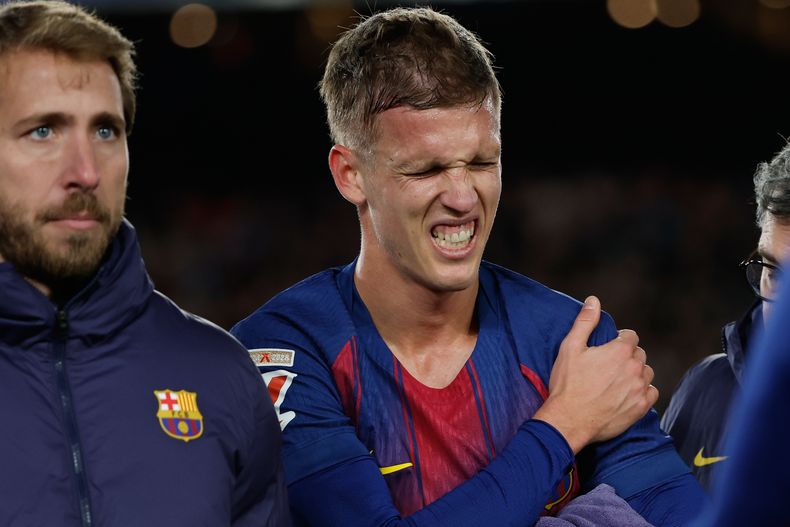 Dani Olmo del Barcelona reacciona adolorido por una lesión del hombro tras marcar un gol ante el Atlético de Madrid en la Liga española, el martes 2 de diciembre de 2025, en Barcelona. (AP Foto/Joan Monfort)