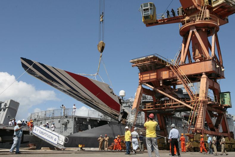 ARCHIVO - Trabajadores descargan restos del Vuelo 447 de Air France desde la fragata Constitución de la Marina brasileña en el puerto de Recife, en el nordeste de Brasil, el domingo 14 de junio de 2009. (AP Foto/Eraldo Peres, Archivo)