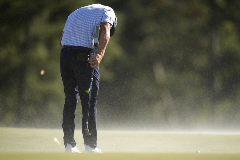 Bryson DeChambeau se agacha para soportar el viento en la segunda ronda del Masters de Augusta, el viernes 12 de abril de 2024 (AP Foto/Ashley Landis)