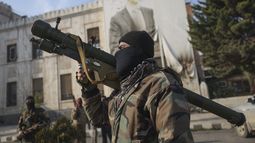 Un combatiente sirio de oposición sostiene un lanzacohetes frente a la oficina del gobierno regional, en cuya fachada se muestra una imagen del presidente sirio, Bashar Assad, rodeada de disparos, tras la toma de la ciudad de Hama por parte de la oposición, en Siria, el viernes 6 de diciembre de 2024. (AP Foto/Ghaith Alsayed) Un combatiente sirio de oposición sostiene un lanzacohetes frente a la oficina del gobierno regional, en cuya fachada se muestra una imagen del presidente sirio, Bashar Assad, rodeada de disparos, tras la toma de la ciudad de Hama por parte de la oposición, en Siria, el viernes 6 de diciembre de 2024. (AP Foto/Ghaith Alsayed)