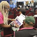 Un organizador de la Red de Acción Nacional registra a la gente antes de una gira en autobús de Get Out the Vote hacia Filadelfia en el barrio de Harlem de Nueva York el viernes 27 de septiembre de 2024. (AP Foto/Noreen Nasir)