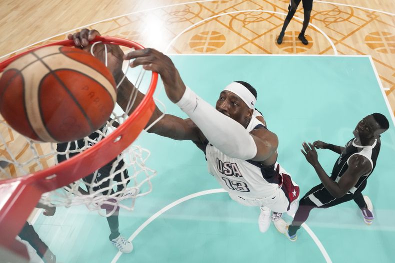 El estadounidense Bam Adebayo completa la volcada ante Peter Jok, jugador de Sudán del Sur, en el baloncesto de los Juegos Olímpicos de París, el miércoles 31 de julio de 2024, en Villeneuve-dAscq, Francia. (AP Fhoto/Mark J. Terrill, Pool)