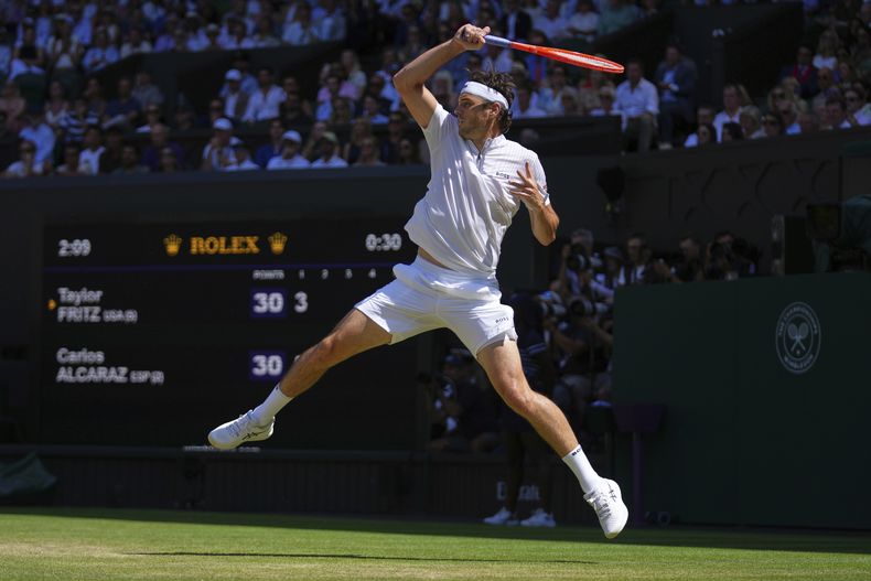 El estadounidense Taylor Fritz regresa el tiro del español Carlos Alcaraz en la semifinal de Wimbledon el viernes 11 de julio del 2025. (AP Foto/Joanna Chan)