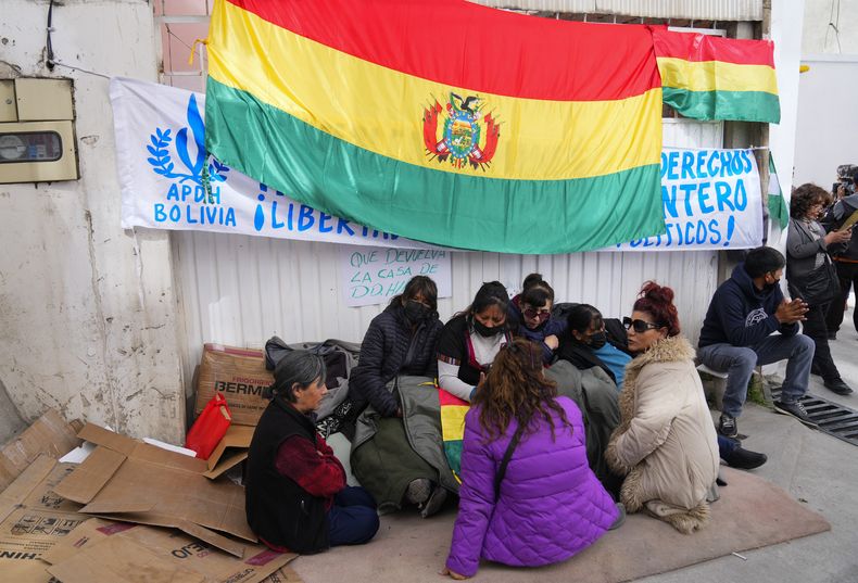 Activistas de derechos humanos se sientan frente a la sede de la Asamblea Permanente de Derechos Humanos de Bolivia (APDHB) en apoyo de Amparo Carvajal en La Paz, Bolivia, el lunes 12 de junio de 2023. (AP Foto/Juan Karita)