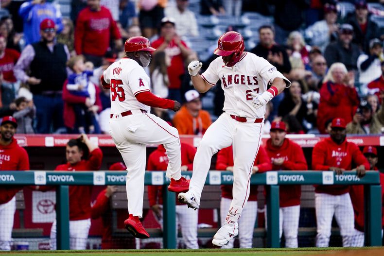 Mike Trout (derecha) festeja con Eric Young, coach de la antesala de los Angelinos de Los Ángeles, luego de batear un jonrón en el juego del martes 23 de abril de 2024 ante los Orioles de Baltimore (AP Foto/Ryan Sun)