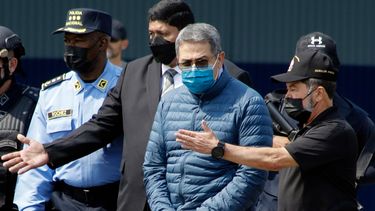 ARCHIVO - El expresidente hondureño Juan Orlando Hernández, segundo de la derecha, es conducido esposado a un avión que lo espera para su extradición a EEUU, en una base aérea de Tegucigalpa, Honduras, el 21 de abril de 2022. (AP Foto/Elmer Martínez/Archivo)