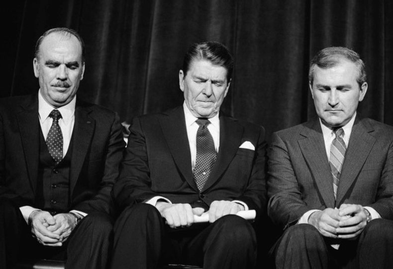ARCHIVO - El presidente Ronald Reagan, centro, ora con el presidente de la Asociación Nacional de Evangélicos, Arthur Gay, izquierda, tras su discurso en la convención de la organización, en el que solicitó ayuda para lograr la aprobación de una enmienda constitucional que permitiera la oración en las escuelas en Columbus, Ohio, el 7 de marzo de 1984. (Foto AP/Barry Thumma, archivo)