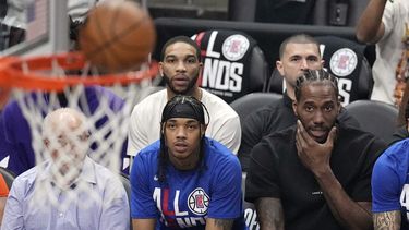 Kawhi Leonard (derecha), de los Clippers de Los Ángeles, observa desde la banca el cuarto partido de la serie de playoffs ante los Suns de Phoenix, el sábado 22 de abril de 2023 (AP Foto/Mark J. Terrill)
