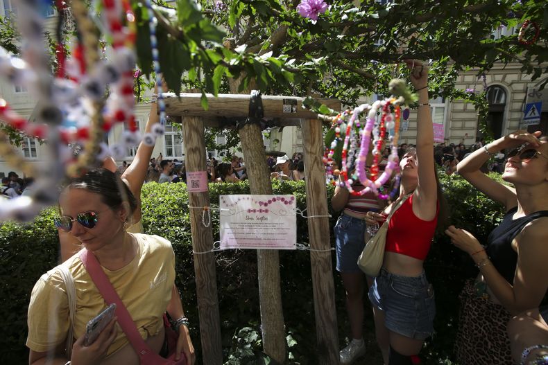 Swifties colocan brazaletes de la amistad en un árbol en el centro de Viena el jueves 8 de agosto de 2024. Los organizadores de tres conciertos de Taylor Swift en un estadio de Viena esta semana los cancelaron el miércoles después de dos arrestos por un aparente complot para lanzar un ataque a un evento masivo en el área de Viena como los conciertos. (Foto AP/Heinz-Peter Bader)