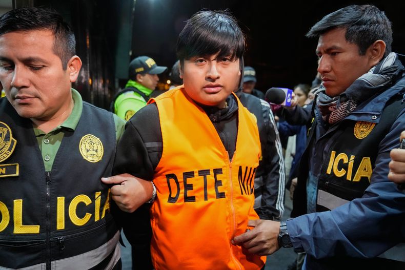 La policía escolta a Tony Janzen Valverde Victoriano, un sospechoso en el asesinato de tres mujeres en Argentina, hacia un cuartel de la policía antinarcóticos, el martes 30 de septiembre de 2025, en Lima, Perú. (AP Foto/Martin Mejia)