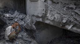 Un hombre sentado afuera del edificio donde vivía que fue destruido durante unos ataques israelíes en el campamento de refugiados de Rafah, en la Franja de Gaza, el martes 17 de octubre de 2023. (AP Foto/Fatima Shbair)