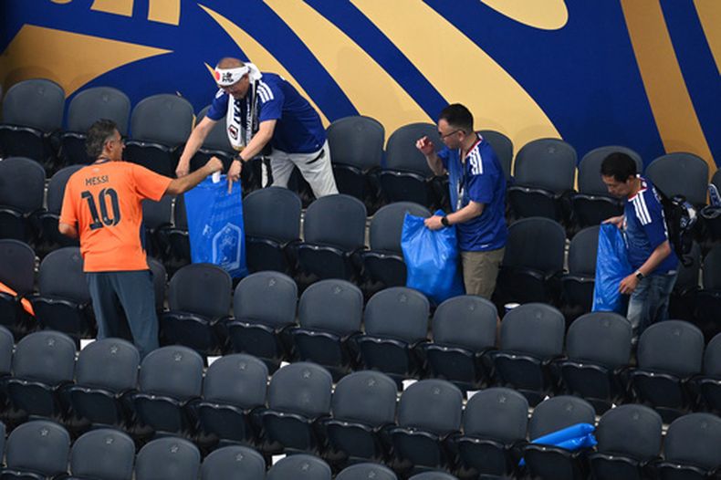 Hinchas de Japón limpian de basura las gradas del estadio de Dallas tras el partido de su selección ante Holanda por el Grupo F del Mundial en Arlington, Texas, Estados Unidos, domingo 14 junio, 2026. (AP Foto/Jessica Tobias)