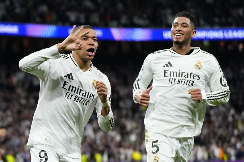 ARCHIVO - kylian Mbappé, izquierda, del Real Madrid, celebra con Jude Bellingham después de anotar el tercer gol de su equipo durante el partido de vuelta del partido de la ronda de eliminación de la Liga de Campeones entre Real Madrid y Manchester City en el estadio Santiago Bernabéu, el miércoles 19 de febrero de 2025, en Madrid, España. (AP Foto/Manu Fernandez, Archivo)