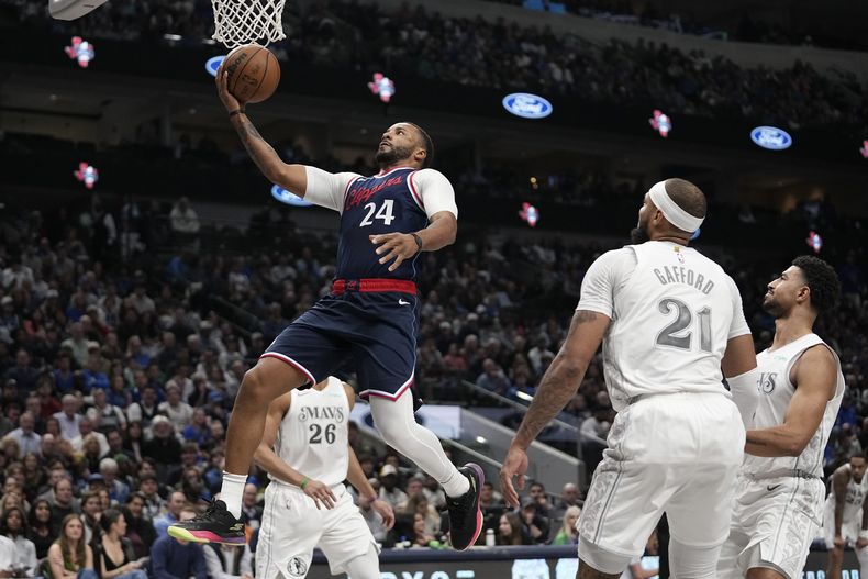 El base de los Clippers de Los Ángeles Norman Powell salta a la canasta frente a Spencer Dinwiddie, Daniel Gafford y Quentin Grimes de los Mavericks de Dallas el jueves 19 de diciembre del 2024. (AP Foto/Tony Gutierrez)