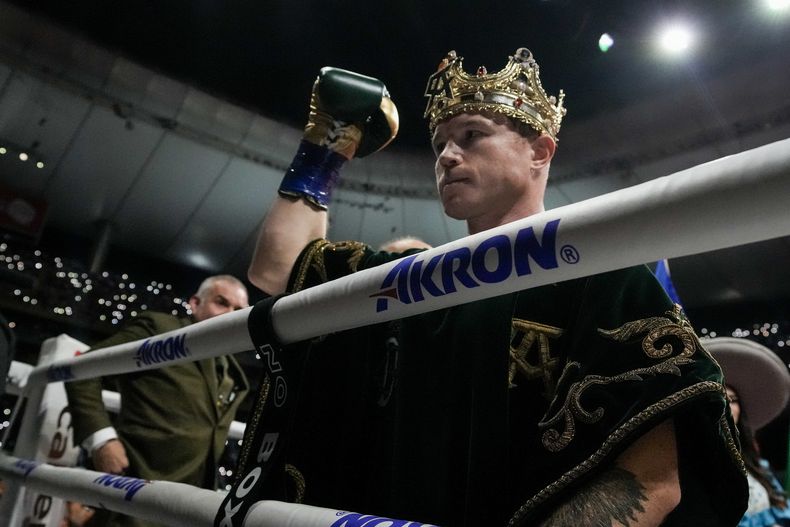 El boxeador mexicano Saúl Canelo Álvarez saluda a los aficionados antes de la pelea por el título del campeonato supermediano frente al británico John Ryder, en el Akron Stadium, en Guadalajara, México, el 6 de mayo de 2023. (AP Foto/Moisés Castillo)