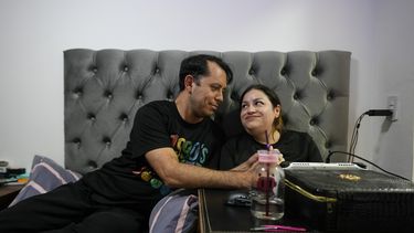 Susana Moreira, de 41 años y que padece una distrofia muscular degenerativa, mira a su esposo en su cuarto en Santiago, Chile, el 10 de abril de 2025. (AP Foto/Esteban Félix)