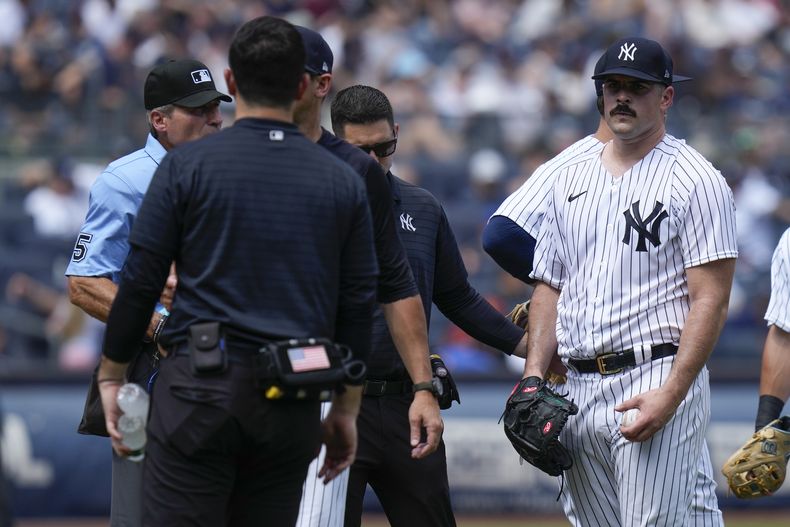 El lanzador de los Yanquis de Nueva York Carlos Rodón (derecha) reacciona mientras es sacado en el tercer episodio del juego ante los Astros de Houston en el Yankee Stadium, en Nueva York. Domingo 6 de agosto de 2023. (AP Foto/Seth Wenig)