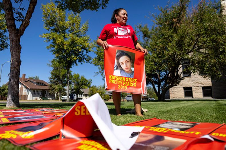 Melissa Lonebear sostiene un cartel con la foto de Kaysera Stops Pretty Places en Hardin, Montana, el 29 de agosto del 2023. (AP foto/Mike Clark)
