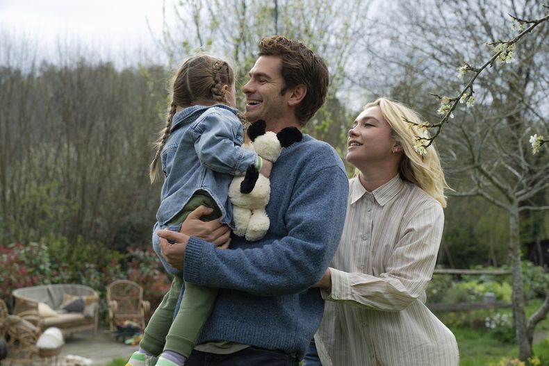 Esta imagen difundida por A24 muestra a Andrew Garfield, en el centro, y Florence Pugh, a la derecha, en una escena de We Live In Time. (Peter Mountain/A24 vía AP)