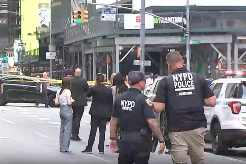 Esta imagen tomada de un video difundido por WABC muestra a agentes del Departamento de Policía de Nueva York en el lugar después de que policías balearon a una mujer que blandía dos enormes cuchillos de cocina, el lunes 31 de agosto de 2026, en Times Square, Nueva York. (WABC vía AP)