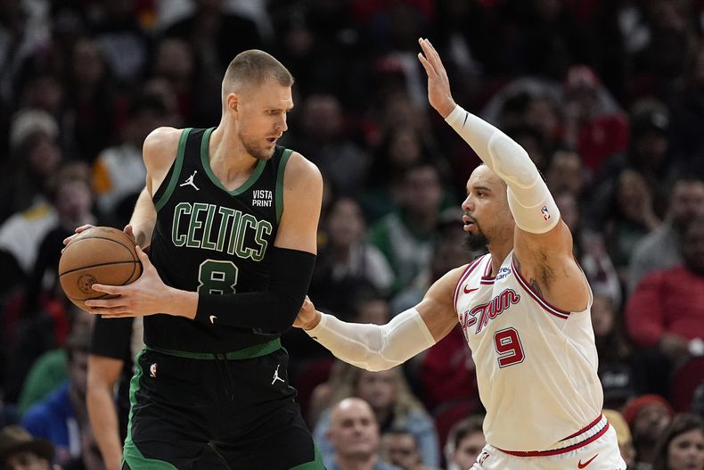 El pívot de los Celtics de Boston Kristaps Porzingis (8) es marcado por Dillon Brooks (9) de los Rockets de Houston durante la segunda mitad del juego de baloncesto de la NBA, el domingo 21 de enero en Houston. (AP Foto/David J. Phillip)